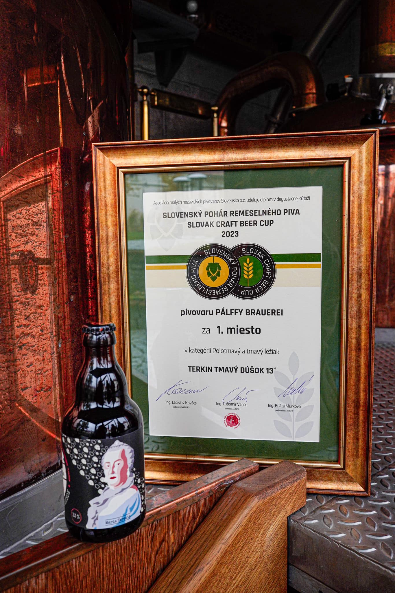 a frame with a beer bottle and a glass bottle