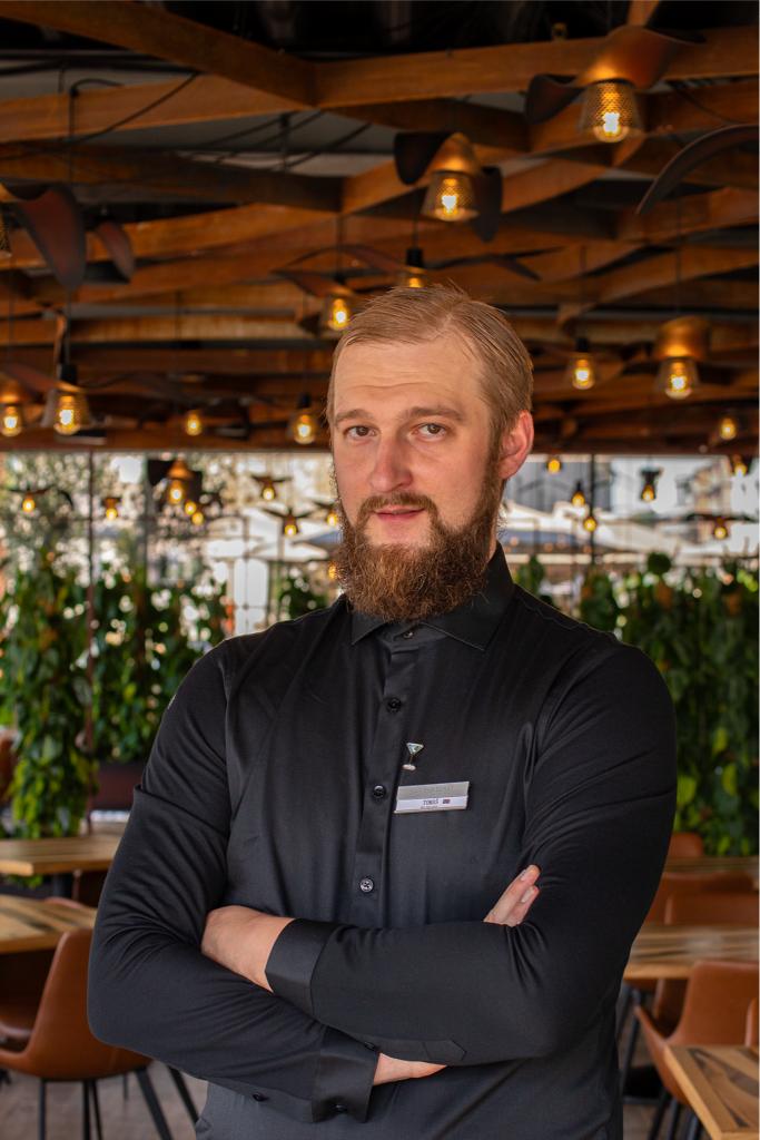 a man with a beard standing in a restaurant